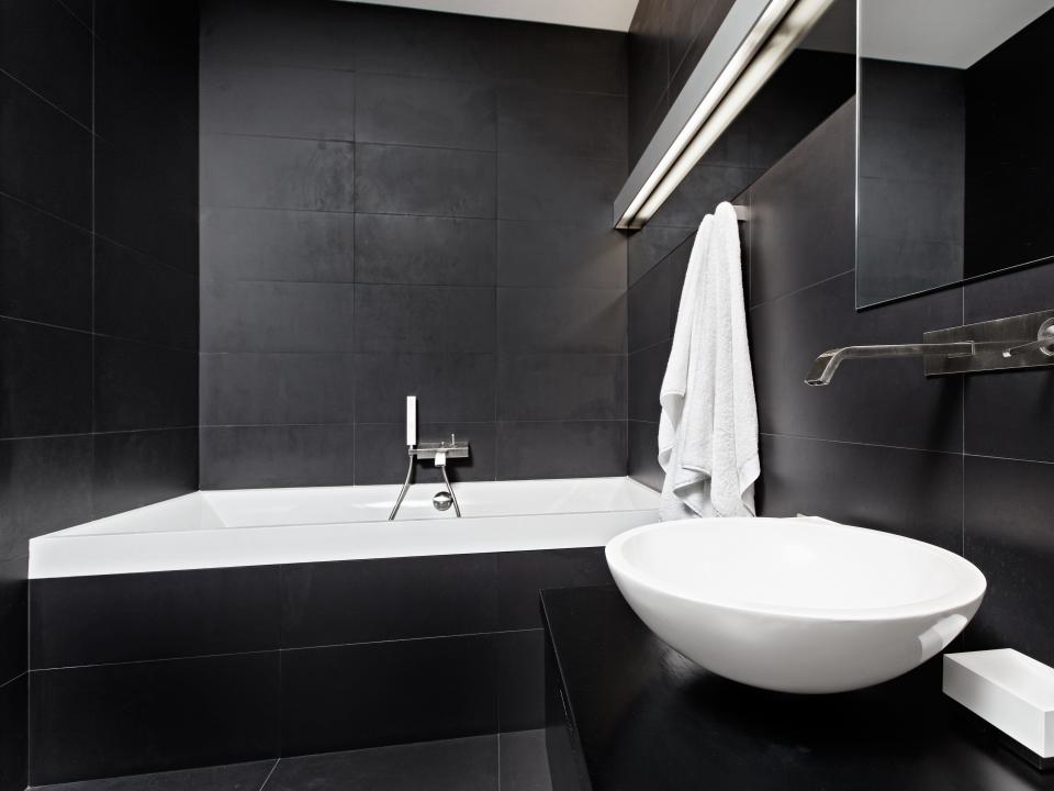 Bathroom with dark gray walls and white tub and sink