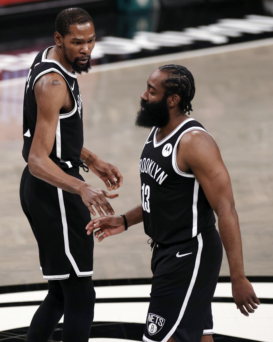 Brooklyn Nets guard James Harden (13) walks off the court past Kevin Durant early in the first quarter of Game 1 of the team's NBA basketball second-round playoff series against the Milwaukee Bucks on Saturday, June 5, 2021, in New York. (AP Photo/Adam Hunger)