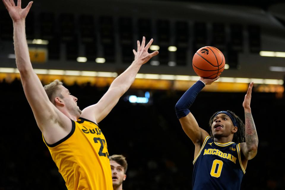 Michigan guard Dug McDaniel (0) shoots over Iowa forward Ben Krikke, left, during the first half at Carver-Hawkeye Arena in Iowa City, Iowa, on Sunday, Dec. 10, 2023.