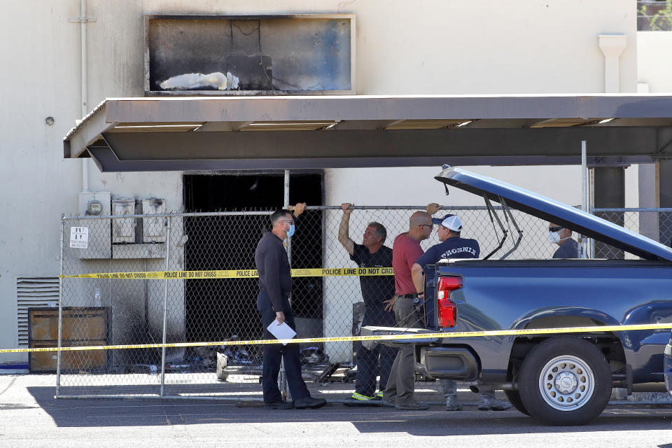 Fire investigators stand outside the Arizona Democratic Party headquarters Friday, July 24, 2020, in Phoenix. Fire investigators are looking into the cause of an early morning blaze that destroyed part of the Arizona and Maricopa County Democratic Party headquarters Friday. (AP Photo/Matt York)