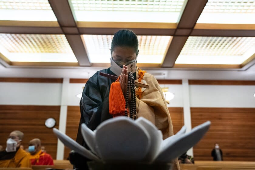 LOS ANGELES, CA - MAY 04: People gild the lily at the Higashi Honganji Buddhist Temple in Los Angeles as the Buddhist Temple conducts a National Buddhist Memorial Ceremony on Tuesday, May 4, 2021 in Los Angeles, CA. This day marks exactly seven weeks, or forty-nine days, since the Atlanta shootings. In many Buddhist traditions, forty-nine days after death marks an important transition for the bereaved.(Jason Armond / Los Angeles Times)