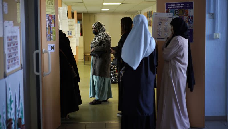 Women wait in line before voting for the first round of the presidential election at a polling station Sunday, April 10, 2022, in the Malpasse northern district of Marseille, southern France. France’s education minister announced on Monday, Aug. 28, 2023 that long robes in classrooms would be banned starting with the new school year, saying that secularism in the nation’s schools is being “tested” via the garments, worn mainly by Muslims.