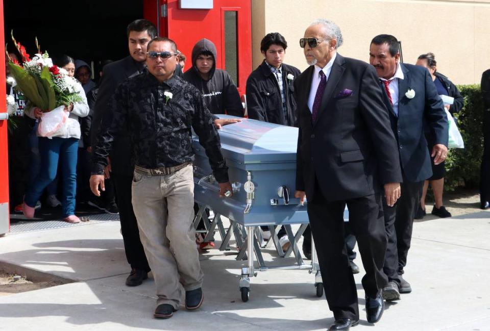 A casket of one of seven farmworkers who died in a Feb. 23 crash on a rural Madera County Road is wheeled out of the Kerman High School multi-purpose room on March 9, 2023.
