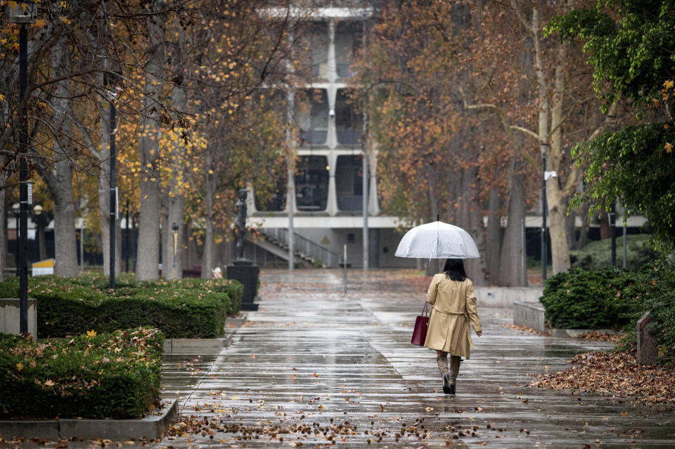 A person walks in the rain in Van Nuys, Calif. (David Crane / The Orange County Register via AP)