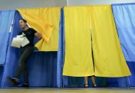 A man leaves a booth at a polling station during at a parliamentary election in Kiev, Ukraine, Sunday, July 21, 2019. The party of new President Volodymyr Zelenskiy is widely predicted to get the largest share of votes in Sunday's election. (AP Photo/Evgeniy Maloletka)