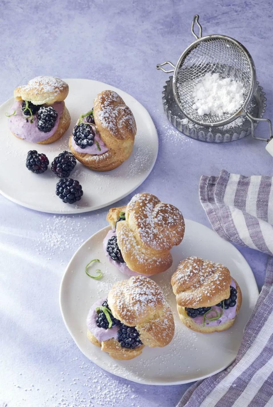 blackberry lime cream puffs on a plate, dusted with sugar