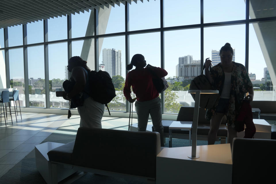 Passengers gather their belongings to board a train from the Fort Lauderdale station, Friday, Sept. 8, 2023, in Fort Lauderdale, Fla. Brightline, which began running its neon-yellow trains between Miami and West Palm Beach in 2018, is the first private intercity passenger service to begin U.S. operations in a century. It's also building a line connecting Southern California and Las Vegas that it hopes to open in 2027. (AP Photo/Marta Lavandier).