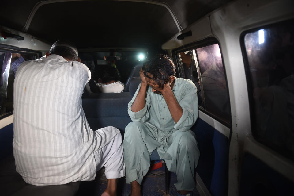 Relatives cover their faces as they arrive jail to pick up the body of Imran Ali. (Getty Images)