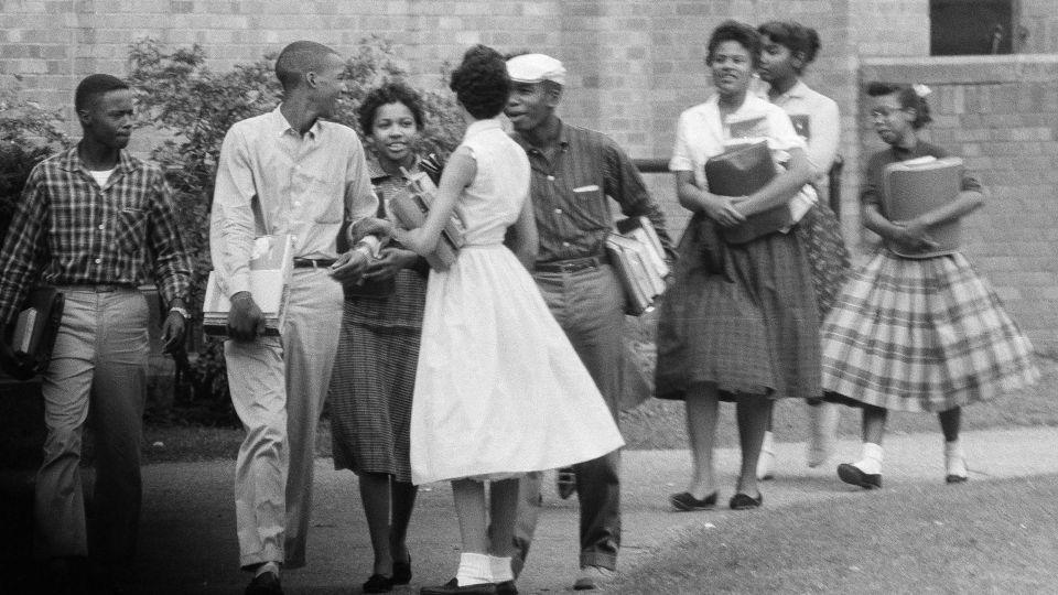 The first Black students to enroll at Central High School in Little Rock, Ark., leave the building and walk toward a waiting Army station wagon following their classes on Oct. 2, 1957.  - Ferd Kaufman/AP