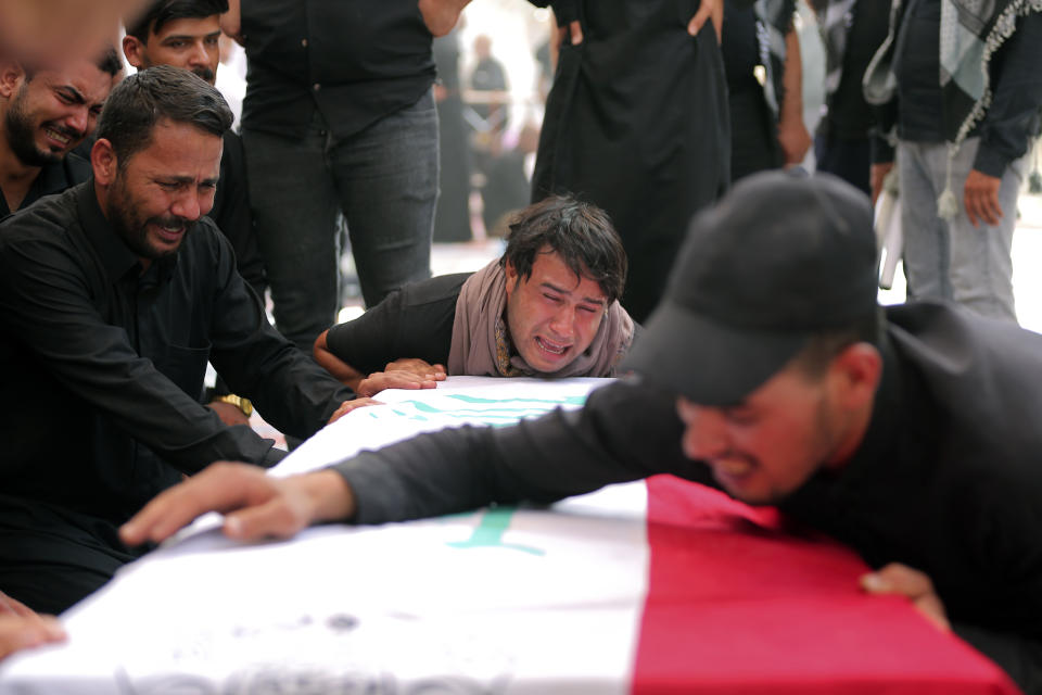 Relatives attend a funeral of a man killed during clashes with security in Baghdad during his funeral in Najaf, Iraq, Tuesday, Aug. 30, 2022. An influential Shiite cleric Muqtada al-Sadr announced Monday that he will resign from Iraqi politics, and hundreds of his angry followers responded by storming the government palace. The move sparked violent clashes with security forces in which at least 15 protesters were killed. (AP Photo/Anmar Khalil)