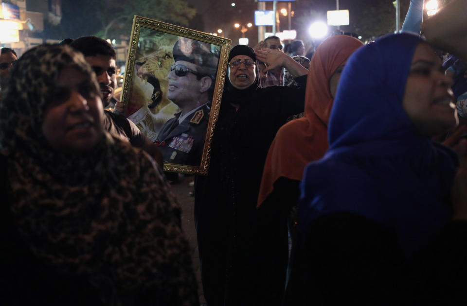 Supporters of Egypt's former army chief Abdel-Fattah el-Sissi gather to watch his first televised interview shown on a big screen in the street in downtown Cairo, Egypt, Monday, May 5, 2014. El-Sissi gave the first TV interview of his campaign to become Egypt's next president on Monday, saying he decided to run because of the threats facing the nation after his removal of the country's first democratically elected president, Islamist Mohammed Morsi. (AP Photo/Khalil Hamra)