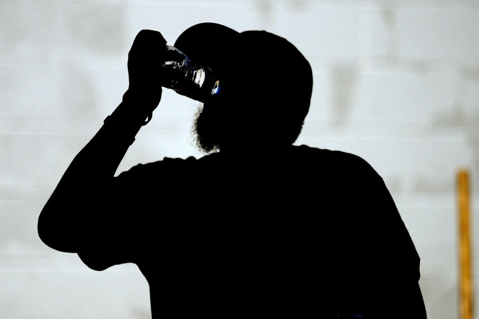 A homeless man drinks a bottle of water outside a Circle The City mobile clinic, Thursday, May 30, 2024 in Phoenix. Based in the hottest big metro in America, Circle the City is taking measures to protect patients from life-threatening heat illness as temperatures hit new highs. Homeless people accounted for nearly half of the record 645 heat-related deaths last year in Arizona's Maricopa County, which encompasses metro Phoenix.(AP Photo/Matt York)