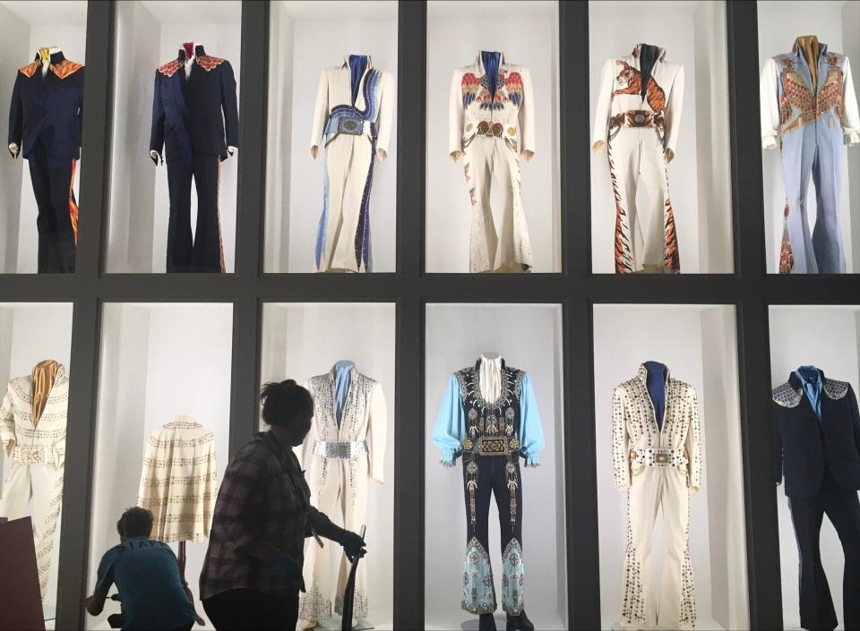 Workers help set up the "Elvis: Dressed to Rock" exhibit at Elvis Presley's Memphis. The exhibit features more than 100 jumpsuits, tunics, capes, belts, pieces of jewelry and pairs of sunglasses worn by the King of Rock 'n' Roll from 1969 to 1977.