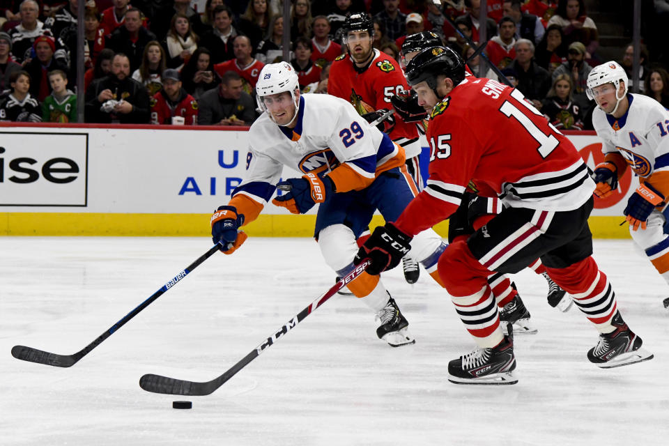 Chicago Blackhawks center Zack Smith (15) moves the puck as New York Islanders center Brock Nelson (29) defends during the first period of an NHL hockey game Friday, Dec. 27, 2019, in Chicago. (AP Photo/Matt Marton)