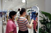 A woman shops using AR make up at a cosmetic shop in a department store in Seoul