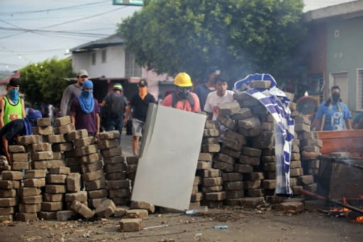 Demonstrators protect themselves behind barricades last month in the Nicaraguan town of Masaya