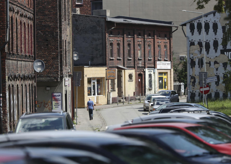 Cars sit outside the closed Wujek coal mine in Katowice, Poland, Saturday, July 4, 2020. The coronavirus has ripped through Poland's coal mines, forcing many to stay home from work and triggering a three-week closure of many state-run mines. (AP Photo/Czarek Sokolowski)