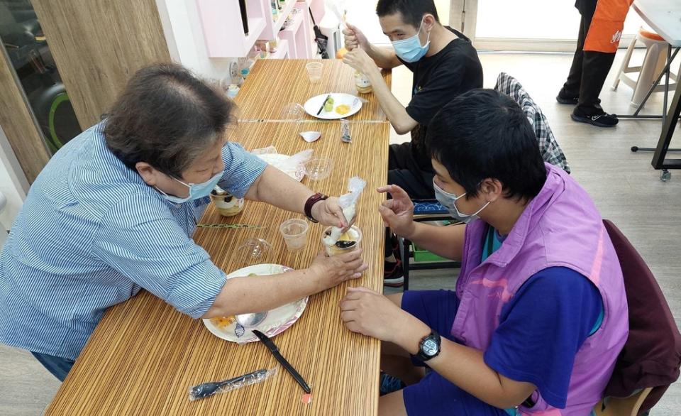 《圖說》碧珠阿姨(左)與三峽國光日照中心服務對象阿翔(右)合作體驗蛋糕DIY。〈社會局提供〉