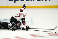 Los Angeles Kings defenseman Sean Walker, left, and Arizona Coyotes left wing Lawson Crouse fall as they go after the puck during the first period of an NHL hockey game Wednesday, March 3, 2021, in Los Angeles. (AP Photo/Mark J. Terrill)