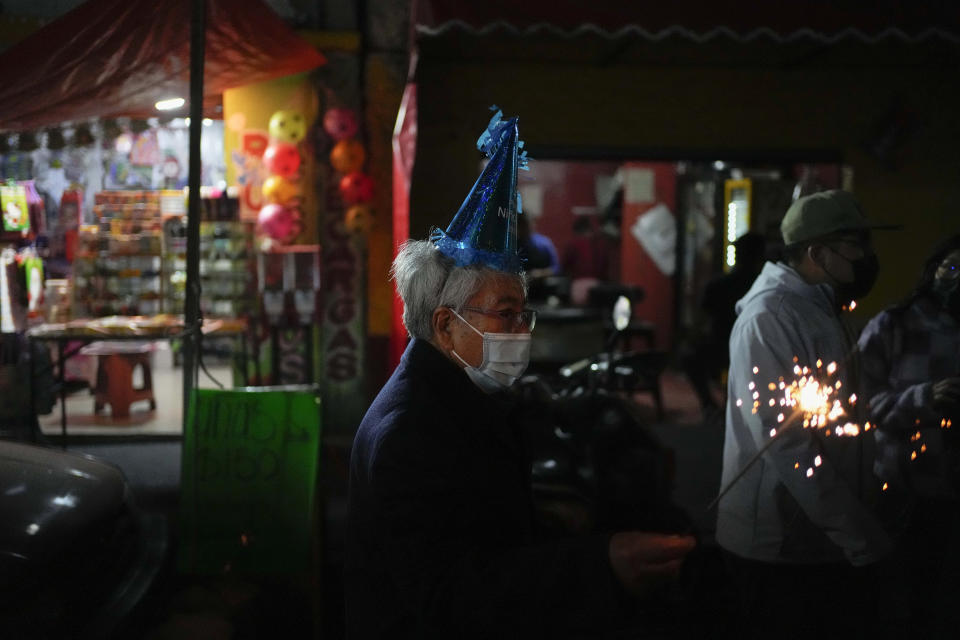 Un hombre con una bengala participa en la procesión de "Niñopa" durante una "posada" navideña en la delegación Xochimilco de la Ciudad de México, el miércoles 21 de diciembre de 2022. Durante los últimos 400 años, los residentes han realizado posadas entre los días 16 y 24 de diciembre, cuando llevan las estatuas del niño Jesús en procesión en conmemoración del frío y difícil viaje de María y José desde Nazaret a Belén en busca de refugio. (AP Foto/Eduardo Verdugo)