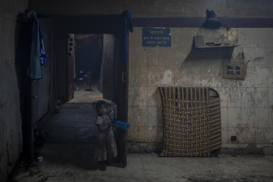 A young girl holds plastic bottles inside a dilapidated shelter for homeless people in New Delhi, Wednesday, Dec. 28, 2022. Official figures also show the city’s 195 homeless shelters can accommodate only about 19,000 people, leaving tens of thousands struggling to keep warm. (AP Photo/Altaf Qadri)