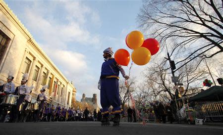 A clown hands out balloons before the start of the 87th Macy's Thanksgiving Day Parade in New York November 28, 2013. REUTERS/Gary Hershorn