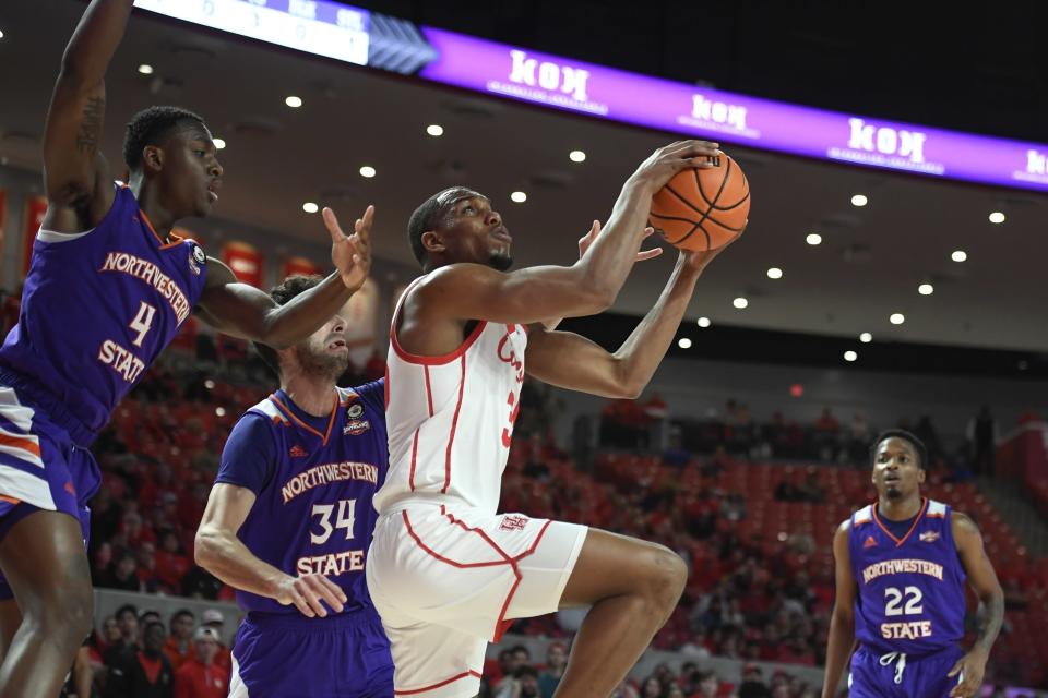 Houston forward Fabian White Jr. shoots in front of Northwestern State center Kendal Coleman (4) and forward Robert Chougkaz (34) during the first half of an NCAA college basketball game Tuesday, Nov. 30, 2021, in Houston. (AP Photo/Justin Rex)
