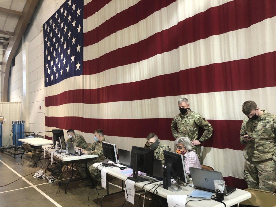 Members of the West Virginia National Guard monitor statewide efforts to distribute COVID-19 vaccines Thursday, Jan. 14, 2021, at the National Guard Joint Forces headquarters in Charleston, W.Va. West Virginia has emerged an unlikely success in the nation's otherwise chaotic vaccine rollout. Officials also credit a 50-person command center at the state's National Guard headquarters just outside the capital of Charleston. (AP Photo/John Raby)