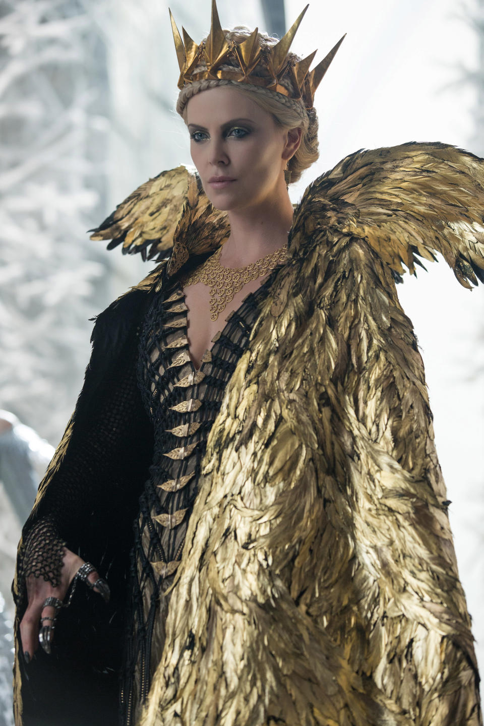 charlize in character in a long feathery robe