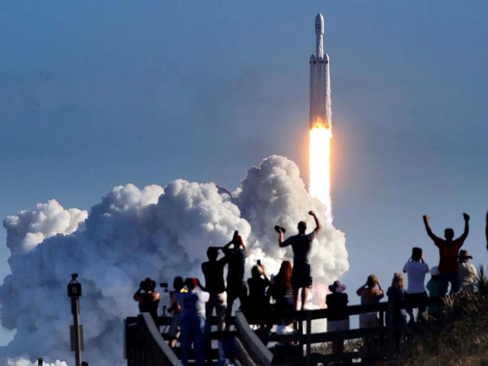 The crowd cheers at Playalinda Beach in the Canaveral National Seashore, just north of the Kennedy Space Center, during the launch of the SpaceX Falcon Heavy rocket, on Feb. 6, 2018.