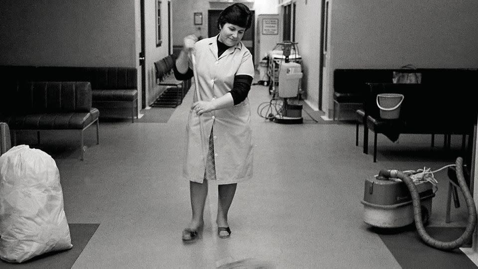 A hospital domestic worker pictured in the 1980s. New book "The National Health Service" says that the health service's ancillary staff — including laundry workers, cleaners, caterers, porters and maintenance staff — have been "critical to the success of the NHS, yet historically among the worst paid people in the country." - Chris Porsz