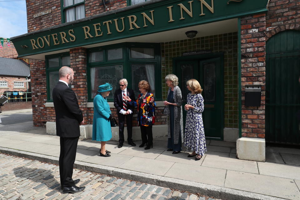 Britain's Queen Elizabeth II meets actors William Roache, fourth right, Barbara Knox, third right, Sue Nicholls and Helen Worth, right, during a visit to the set of the long running television series Coronation Street, in Manchester, England, Thursday July 8, 2021. (AP Photo/Scott Heppell)