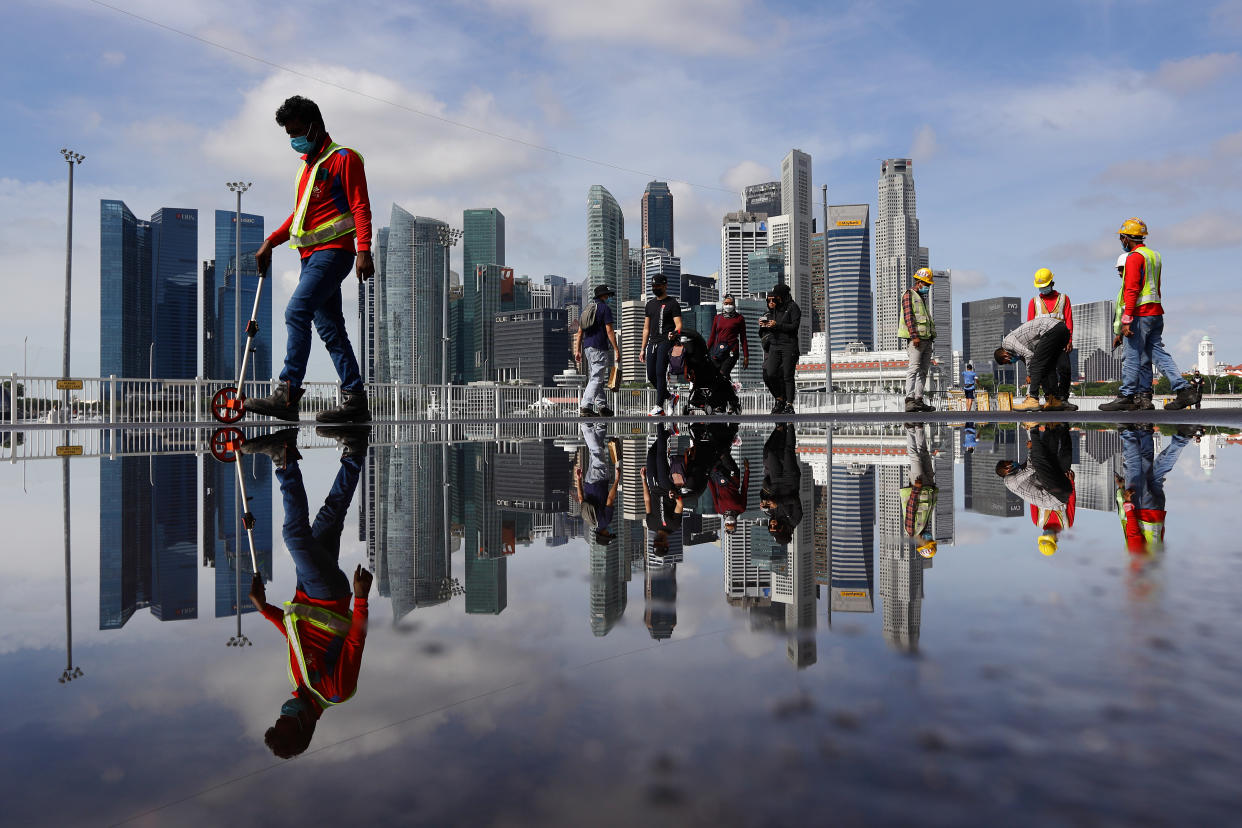 A group of migrant workers conducting road surface checks near Marina Bay (PHOTO: Getty Images)