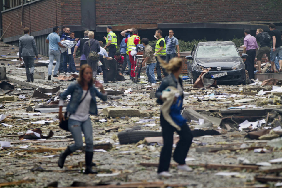 NORWAY OUT Two women walk over debris while rescue workers in the background interact with people near an explosion site in Oslo after two bombs rocked the Norwegian capital on July 22, 2011. Militants staged twin bomb and shooting attacks in Norway Friday, leaving at least 11 dead as a blast tore through government buildings and a gunman opened fire at a youth meeting of the ruling party. Many were also reported wounded from the bomb blast in central Oslo and the shooting at a summer school meeting of Prime Minister Jens Stoltenberg's ruling Labour Party outside the capital. AFP PHOTO / SCANPIX / THOMAS WINJE OIJORD (Photo credit should read THOMAS WINJE OIJORD/AFP/Getty Images)