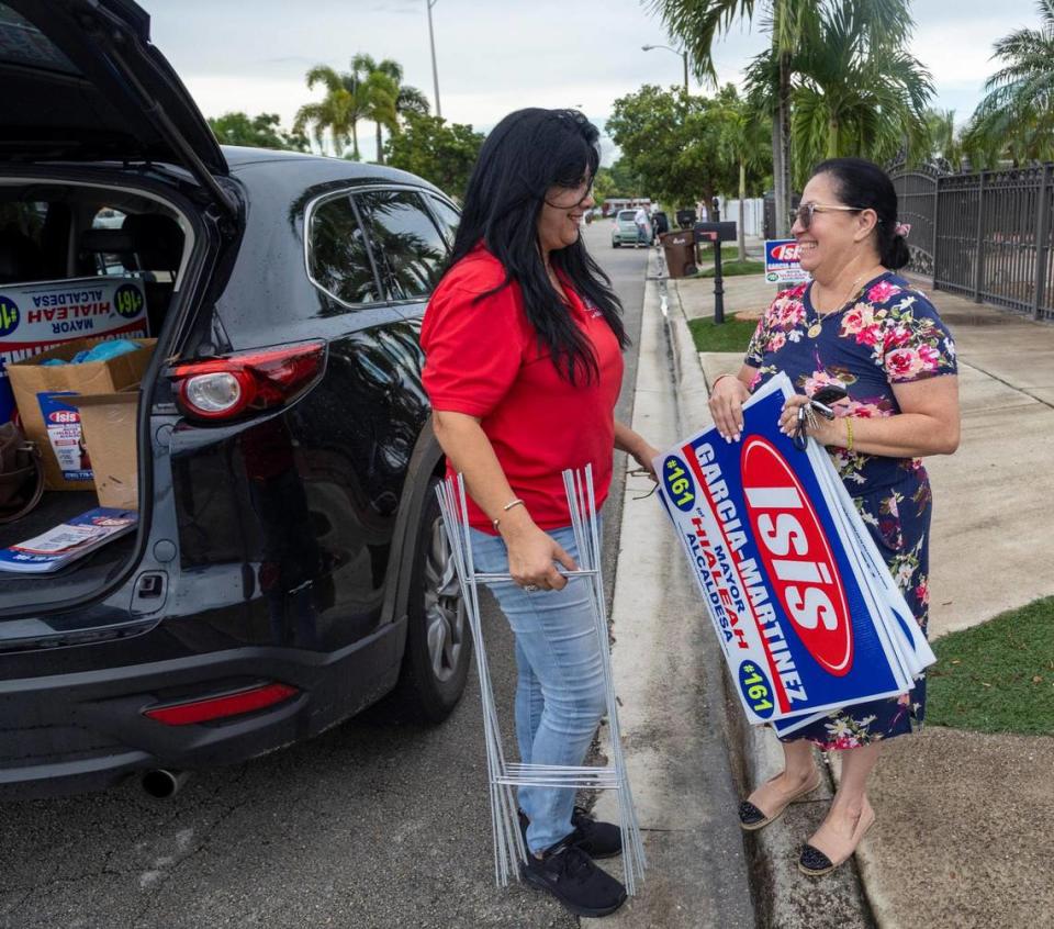 Hialeah mayoral candidate Isis Garcia-Martinez, left, leaves some signs for a supporter on Sept. 24, 2021.