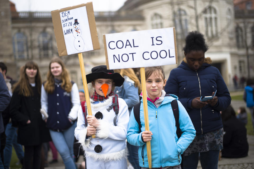 Two girls show their posters, reading : 'The snowman is too warm' and 'Coal is not cool' as they attend a students climate strike as part of the Friday's For Future movement in Berlin, Friday, April 5, 2019. (AP Photo/Markus Schreiber)