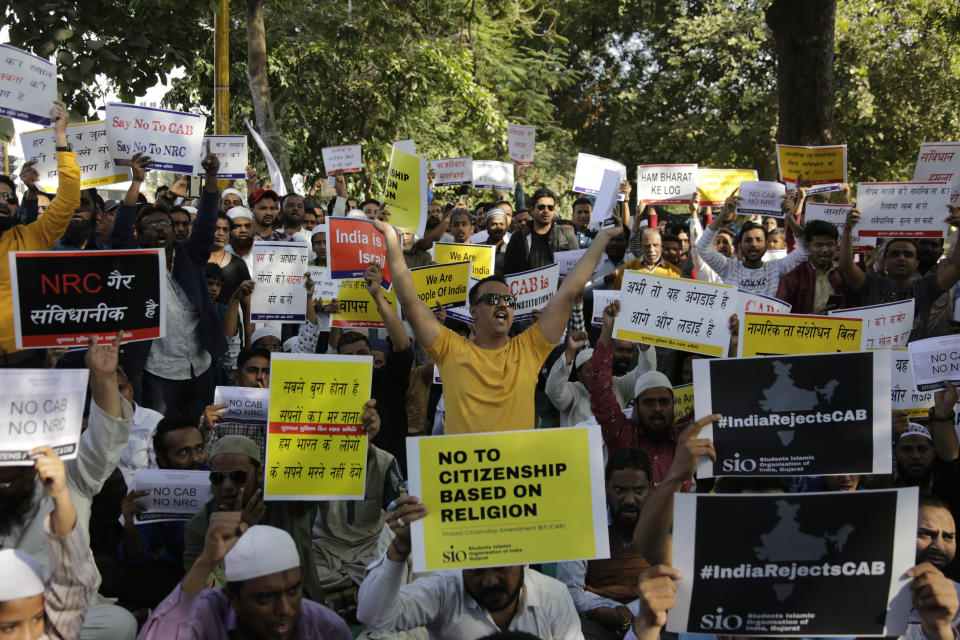 Indians holds placards and shouts slogans during a protest against Citizenship Amendment Act in Ahmadabad, India, Sunday, Dec. 15, 2019. Protests have been continuing over a new law that grants Indian citizenship based on religion and excludes Muslims. (AP Photo/Ajit Solanki)