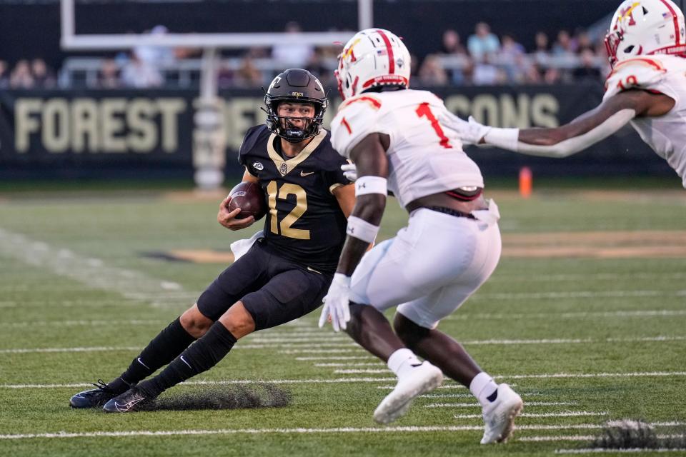 Wake Forest quarterback Mitch Griffis (12) tries to elude Virginia Military Institute defensive back Aljareek Malry during the first half at Truist Field on Thursday night.