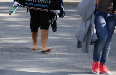 A bare feet migrant walks among others towards Germany at the border crossing with Austria in Freilassing, Germany September 16, 2015. REUTERS/Dominic Ebenbichler