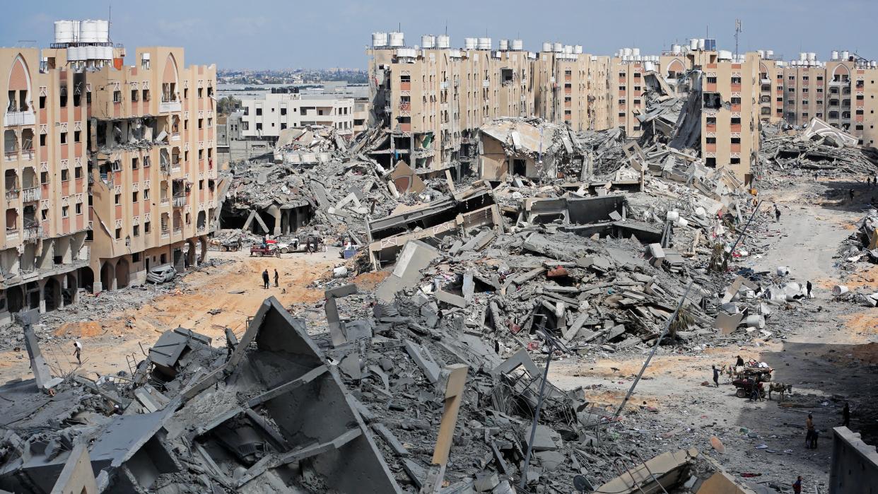  Displaced Palestinians walk amid the rubble of houses destroyed by Israeli bombardment in Hamad area,. 