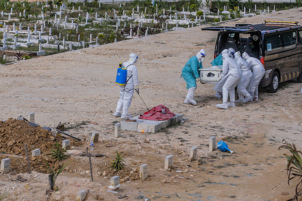 Workers in personal protective equipment prepare to bury the body of a Covid-19 victim at the Muslim cemetery in Gombak June 8, 2021. ― Picture by Hari Anggara