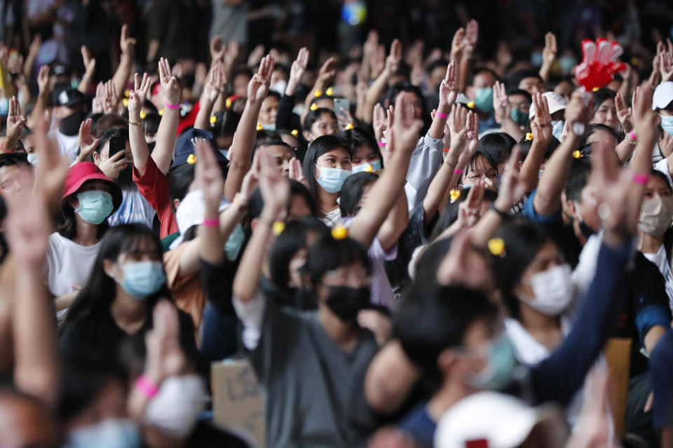 A crowd flashes the three-finger protest gesture during a student rally in Bangkok Saturday, Nov. 21, 2020. Organized by a group that mockingly calls themselves "Bad Students," the rally calls for educational reforms and also supports the broader pro-democracy movement's demands for constitutional change. (AP Photo/Sakchai Lalit)