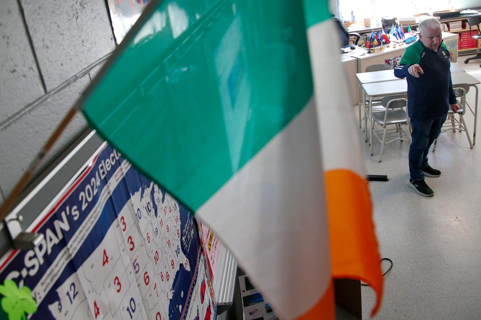 Christopher Donnelly, originally from Derry, Northern Ireland, points to a map showing the amount of electoral votes per state during his social studies class at the Normandin Middle School in New Bedford. Hanging from the wall an Irish flag.