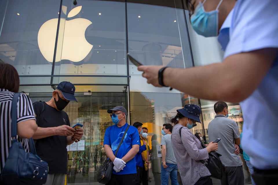 People wearing face masks to protect against the new coronavirus stand outside of an Apple store in Beijing, Saturday, June 6, 2020. China's capital is lowering its emergency response level to the second-lowest starting Saturday for the coronavirus pandemic. That will lift most restrictions on people traveling to Beijing from Wuhan and surrounding Hubei province, where the virus first appeared late last year. (AP Photo/Mark Schiefelbein)