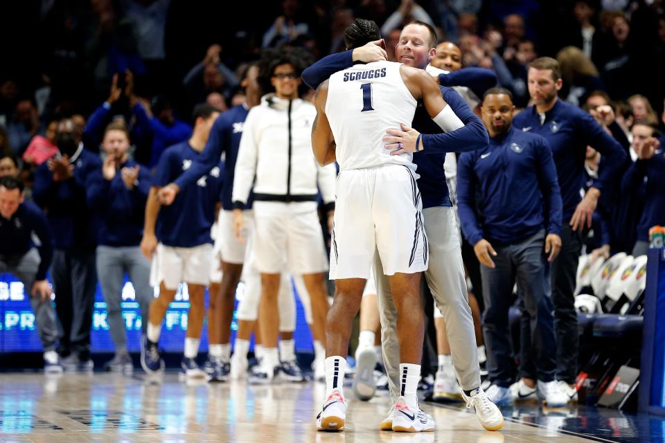 Xavier Musketeers head coach Travis Steele hugs Xavier Musketeers guard Paul Scruggs (1) as he exits the game late in the second half of the 89th Annual Crosstown Shootout basketball game between the Xavier Musketeers and the Cincinnati Bearcats at the Cintas Center in Cincinnati on Saturday, Dec. 11, 2021. Scruggs becomes the first player in Musketeer history to defeat the Bearcats in all four years. 