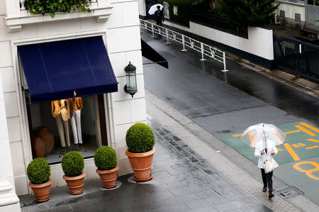 FILE PHOTO: A man walks past a fashion boutique in a shopping district in Tokyo, Japan, May 30, 2016. REUTERS/Thomas Peter/File Photo