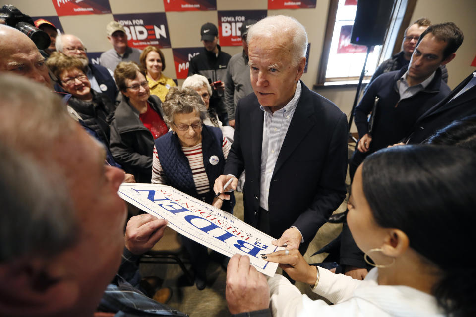 Democratic presidential candidate former Vice President Joe Biden autographs a poster during a meeting with local residents, Monday, Dec. 2, 2019, in Emmetsburg, Iowa. (AP Photo/Charlie Neibergall)