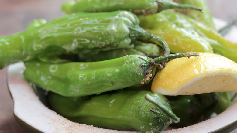 shishito peppers with lemon wedge