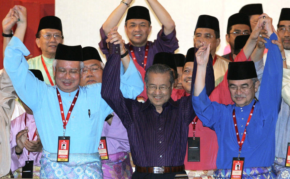 FILE - Malaysia's former Prime Minister Mahathir Mohamad, center, raises hands with then Prime Minister Abdullah Ahmad Badawi, right, and then Deputy Prime Minister Najib Razak at the United Malays National Organization (UMNO) general assembly in Kuala Lumpur, Malaysia, March 28, 2009. Najib Razak on Tuesday, Aug. 23, 2022 was Malaysia’s first former prime minister to go to prison -- a mighty fall for a veteran British-educated politician whose father and uncle were the country’s second and third prime ministers, respectively. The 1MDB financial scandal that brought him down was not just a personal blow but shook the stranglehold his United Malays National Organization party had over Malaysian politics. (AP Photo/Lai Seng Sin, File)