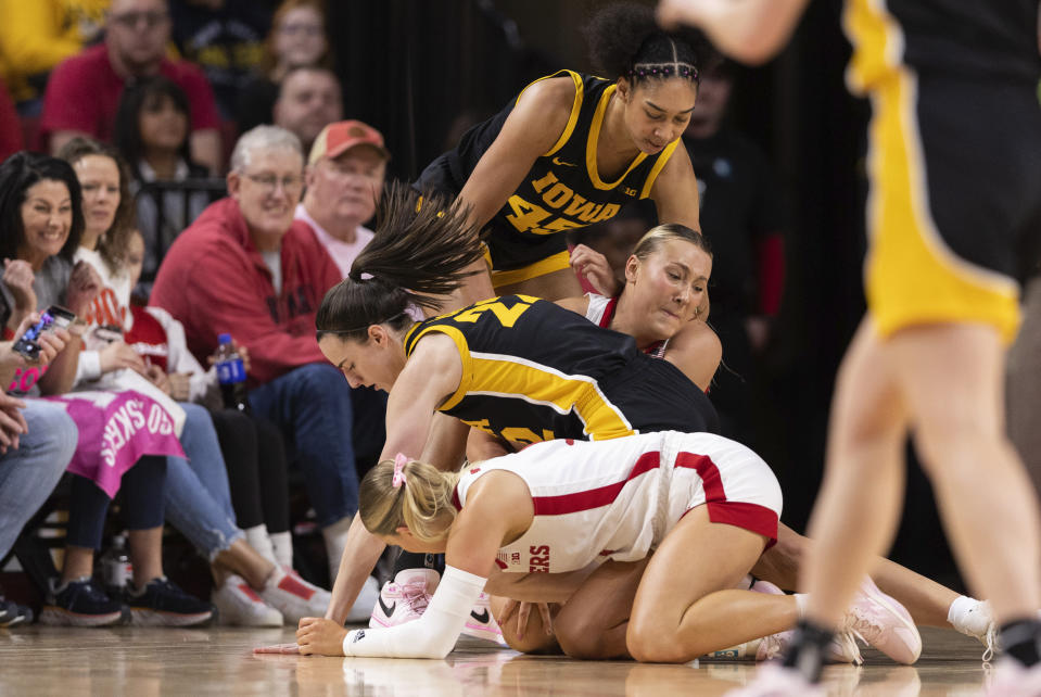 From front to back, Nebraska's Jaz Shelley, reaches for the ball against Iowa's Caitlin Clark, Nebraska's Alexis Markowski and Iowa's Hannah Stuelke during the first half of an NCAA college basketball game Sunday, Feb. 11, 2024, in Lincoln, Neb. (AP Photo/Rebecca S. Gratz)